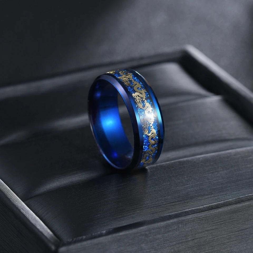 Bague Golden Dragon bleue en acier, ornée de dragons dorés, présentée sur un écrin sombre.