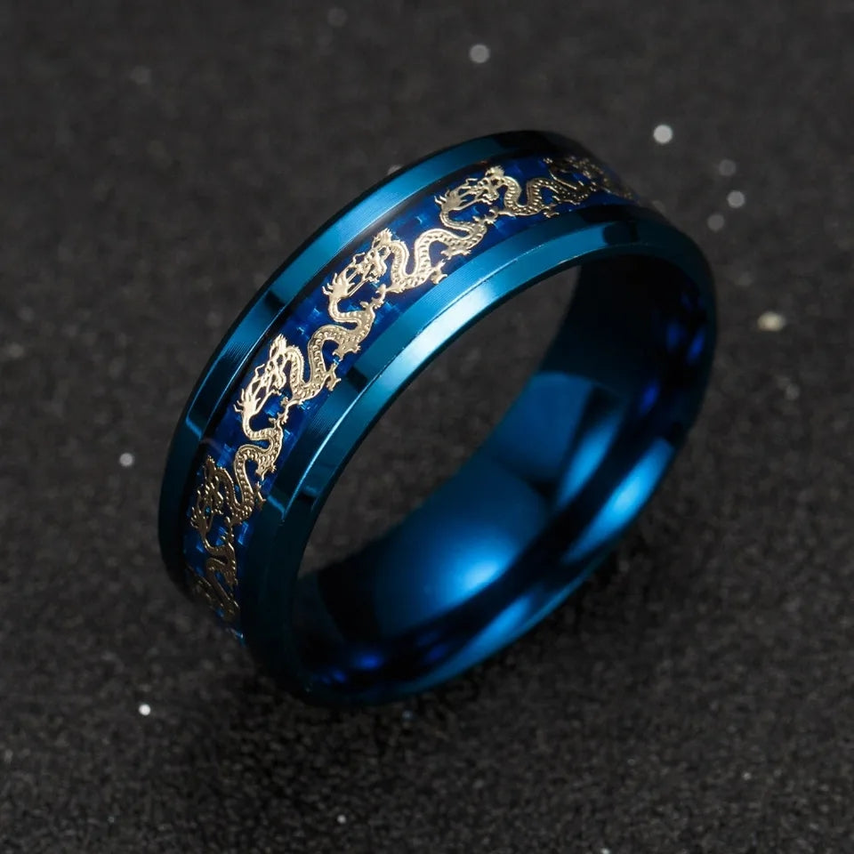 Bague Golden Dragon en acier bleu métallisé, ornée de dragons dorés sur une bande centrale, photographiée de trois quarts sur fond noir.