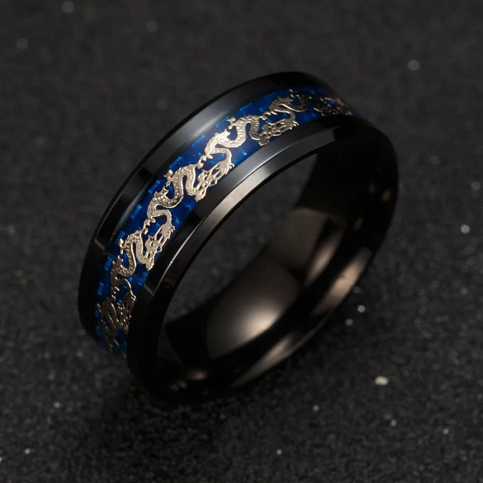 Bague Golden Dragon en acier noir, avec bande bleue et motifs de dragons dorés, photographiée en gros plan sur fond sombre.