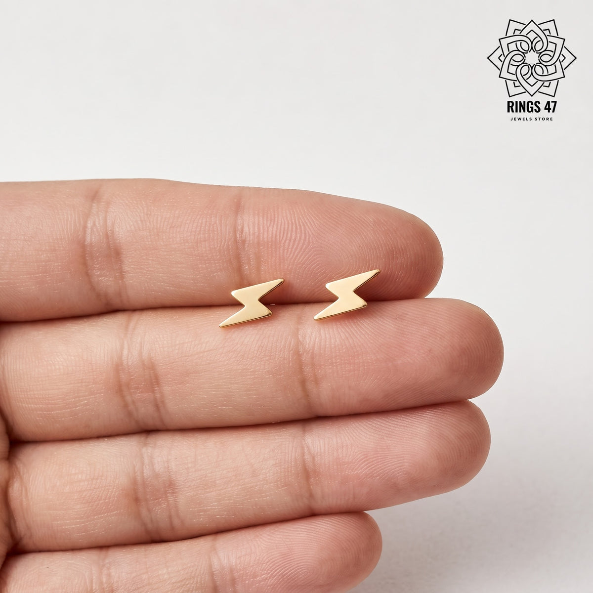 boucles d'oreilles eclairs en evidence sur une main