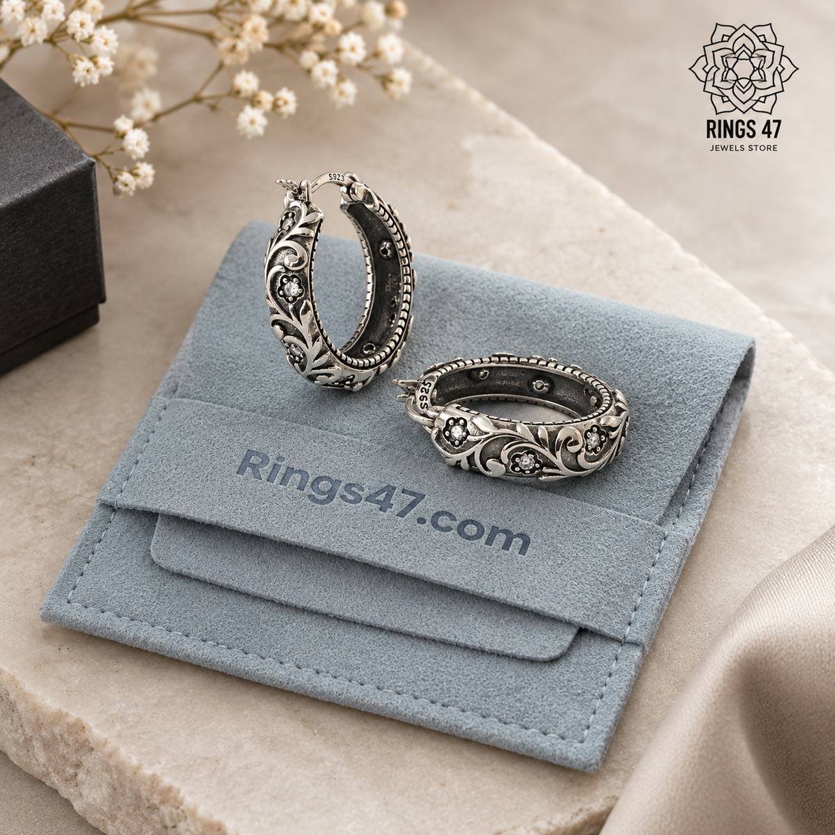 Créoles florales en argent 925 posées sur une pochette Rings47