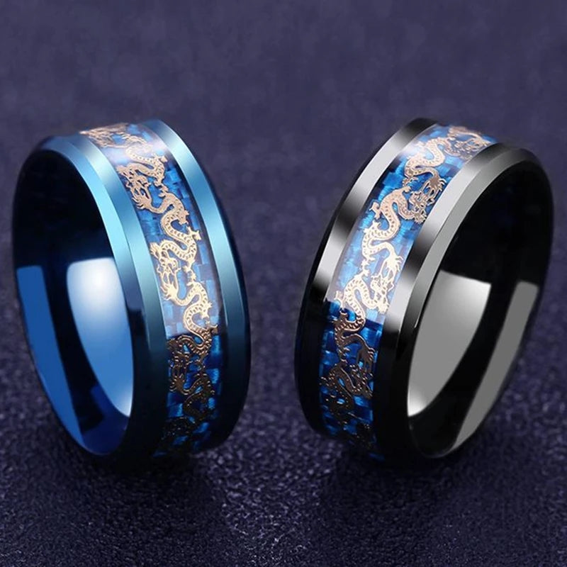 Deux bagues Golden Dragon en acier, finitions bleue et noire, ornées de dragons dorés sur une bande bleue, présentées sur fond sombre.