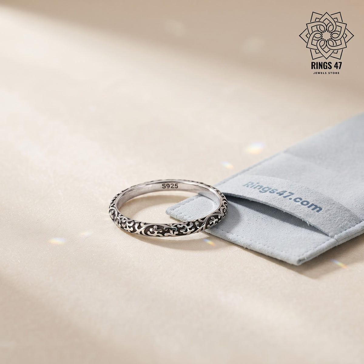 Bague en argent 925 arabesques posée près d'une pochette Rings47