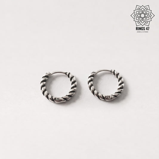 Paire de boucles d'oreilles créoles torsadées en argent 925 sur fond neutre