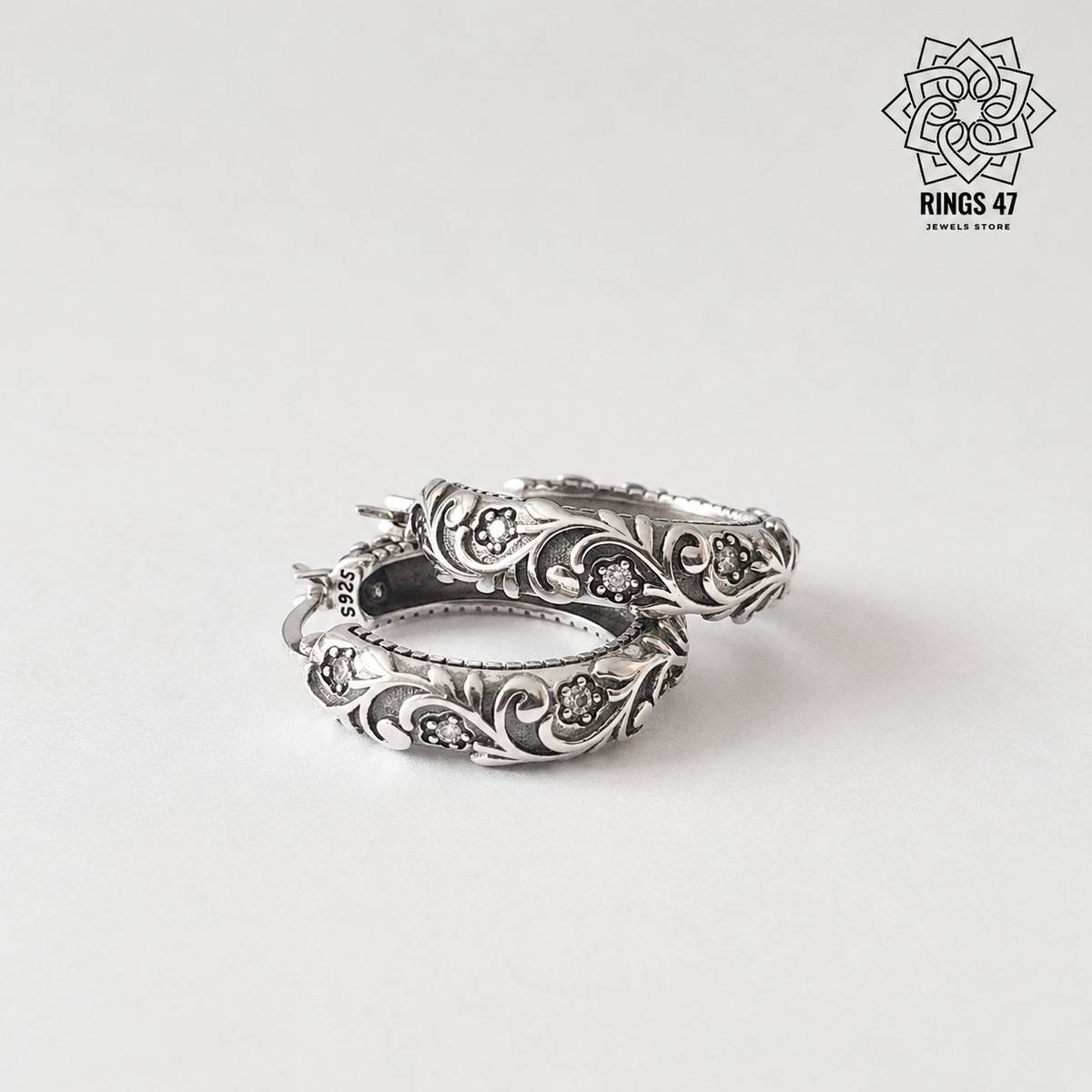 Boucles d'oreilles créoles florales en argent 925 et zirconiums sur fond neutre