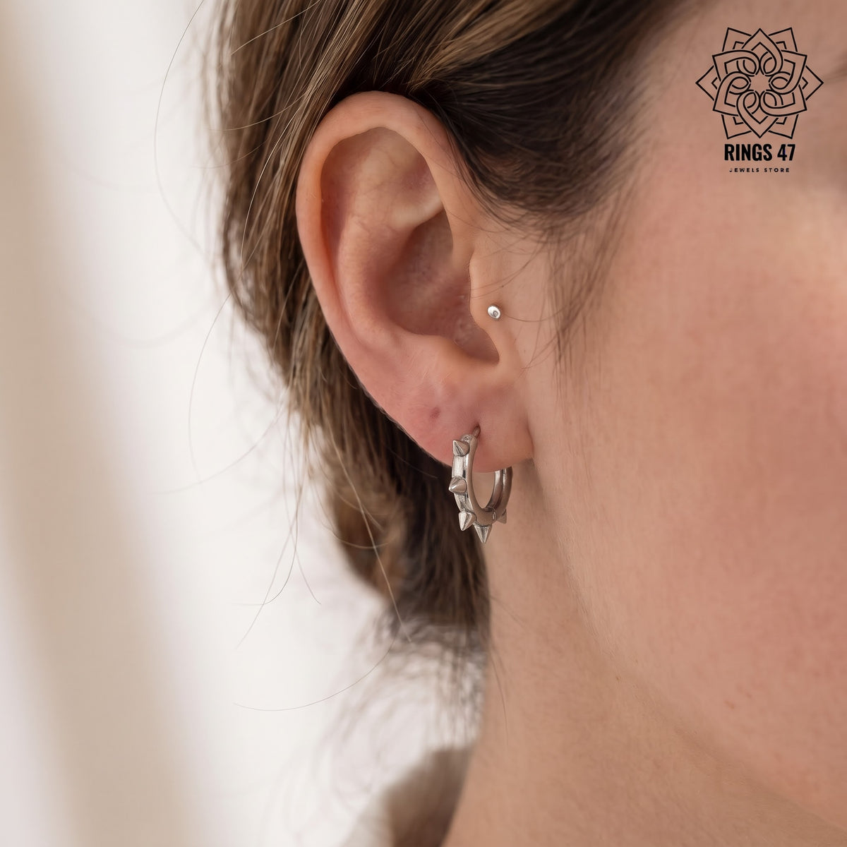 Créole punk à pointes argentée portée à l'oreille